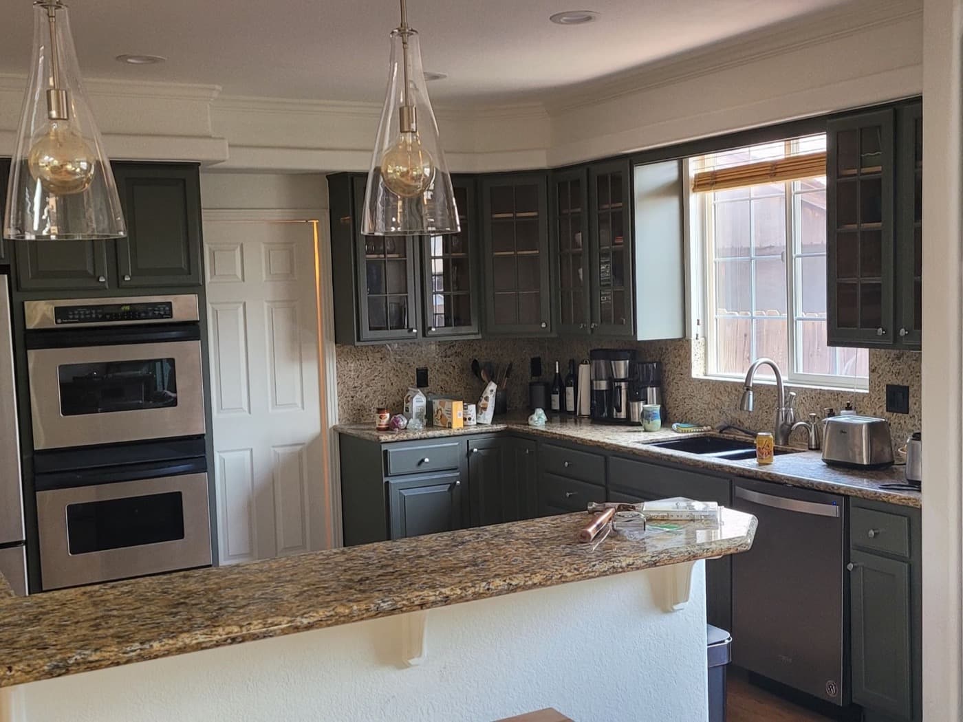 The same kitchen with every cabinet resprayed a deep forest green