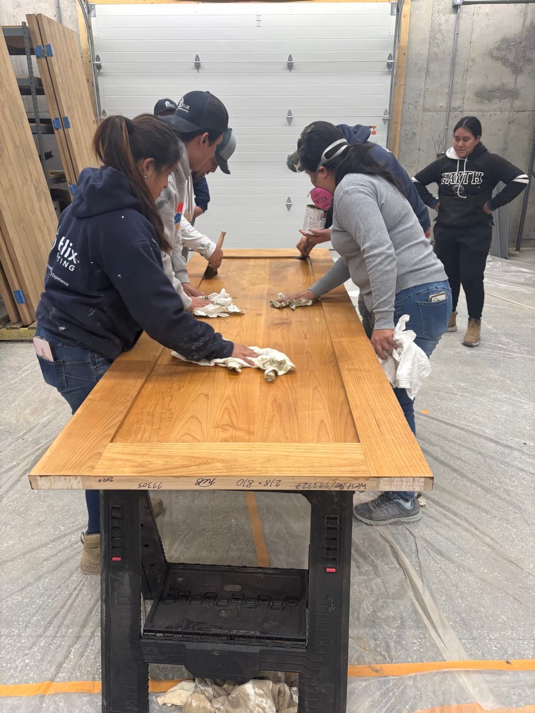 Helix crew hand-staining a solid timber door on a donated project