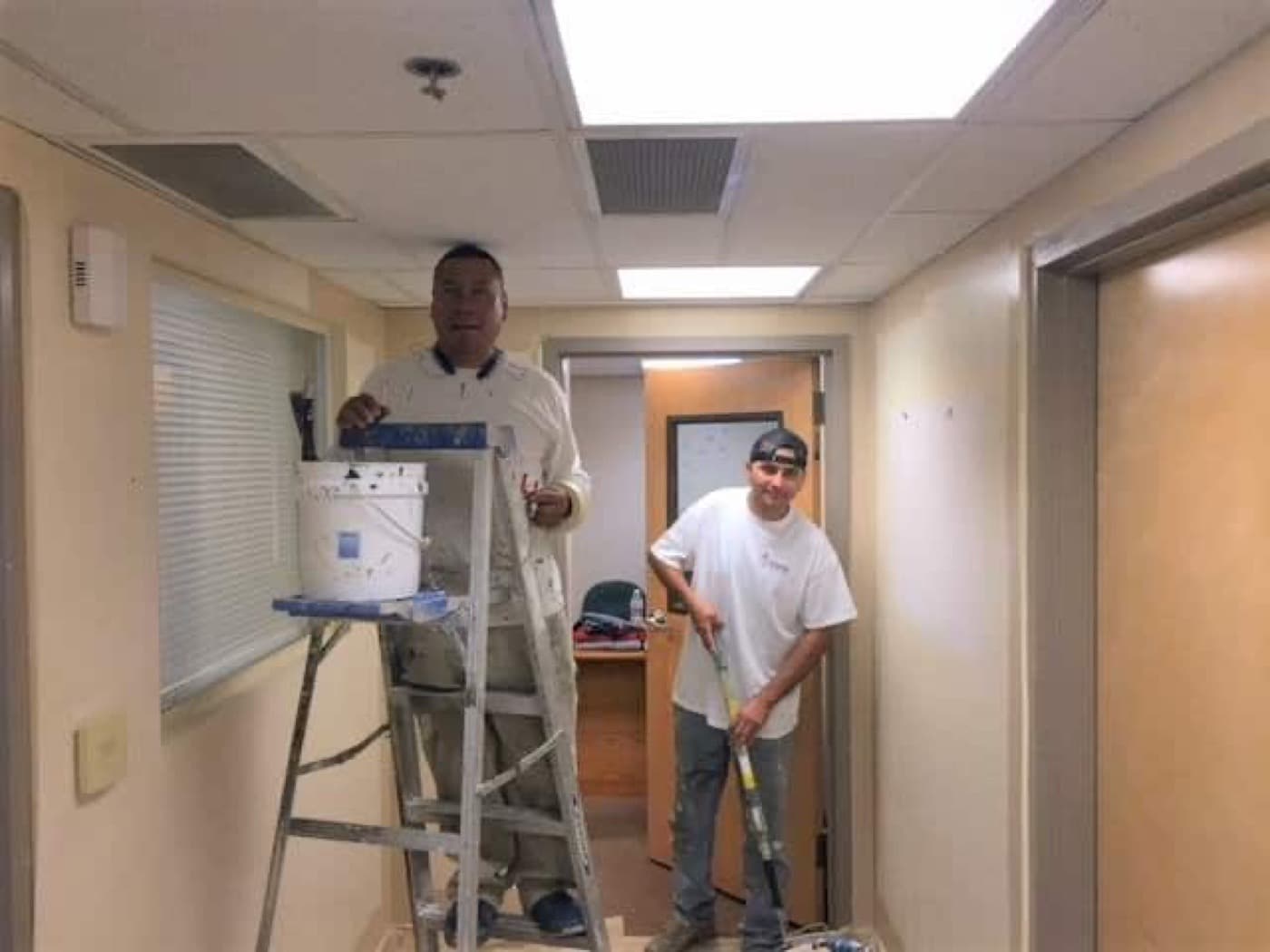 Two Helix painters cutting in the corridor of a nonprofit's offices