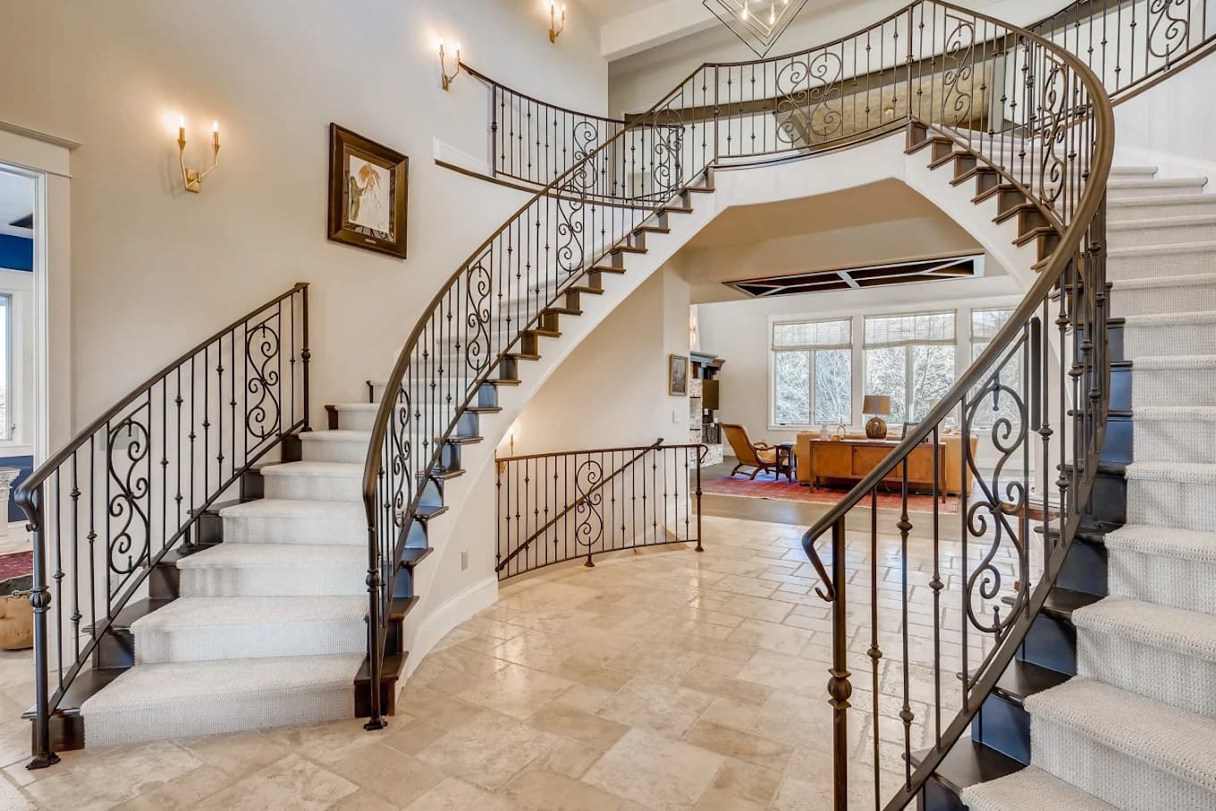 Curved staircase with an iron balustrade and freshly painted walls