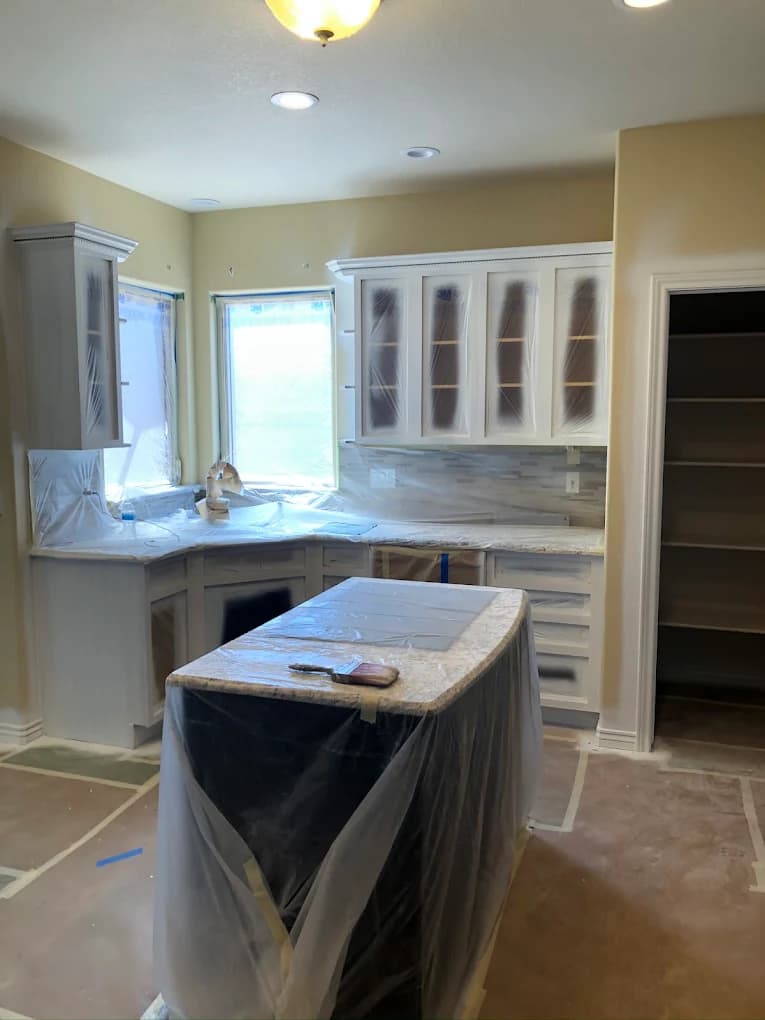 Kitchen cabinetry masked and sheeted before spraying