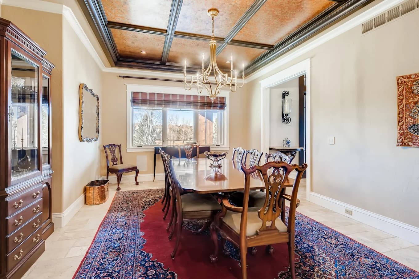 Formal dining room with a painted coffered ceiling, trim and doors