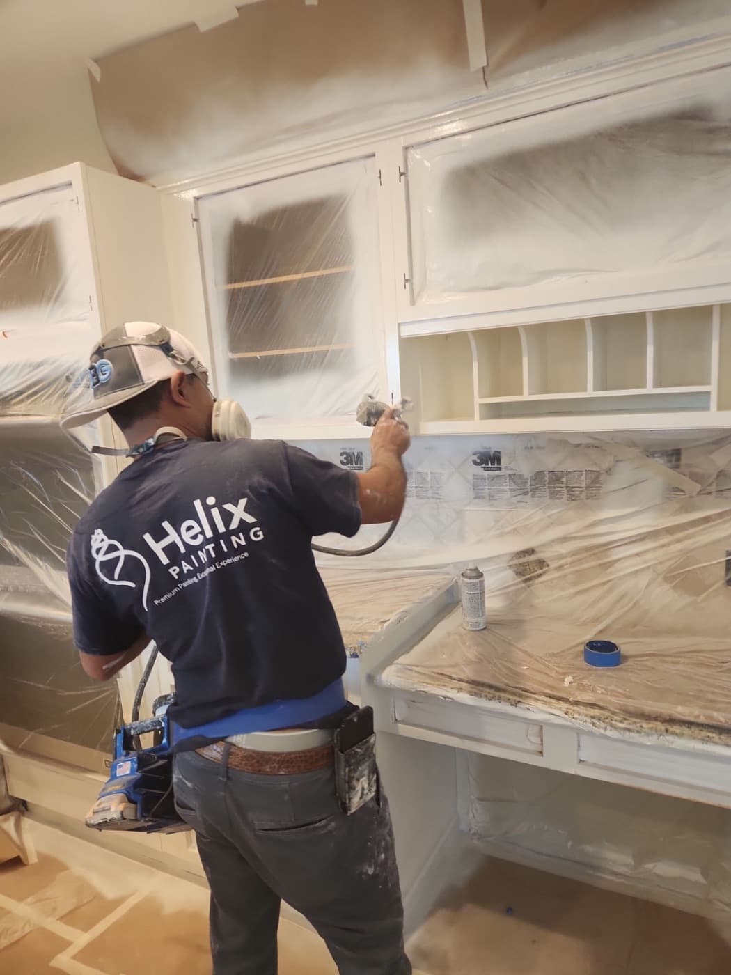 Helix painter spraying kitchen uppers with the whole run masked off