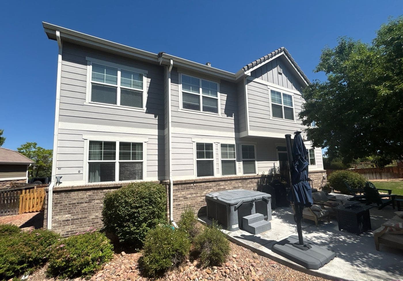 White and gray home exterior with a landscaped side yard