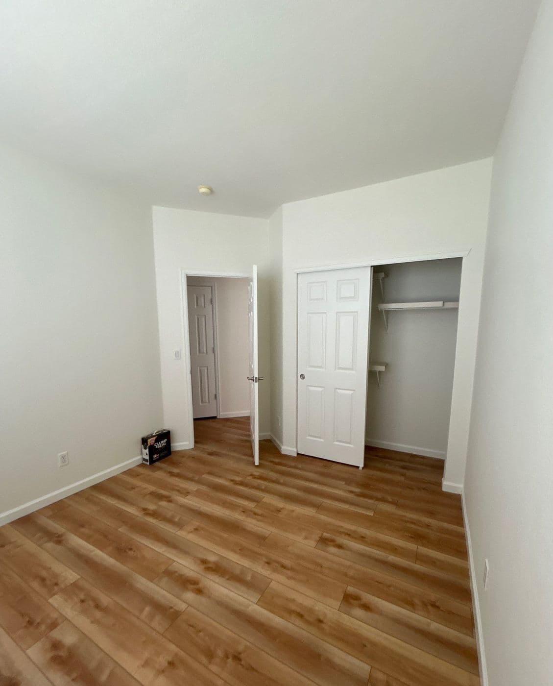 Bedroom repainted in soft white with a hardwood floor