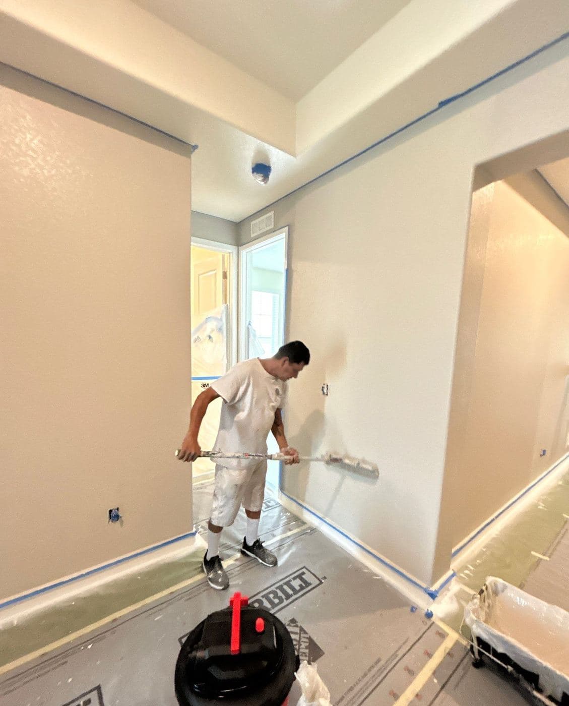 Helix painter rolling an interior wall over a protected floor