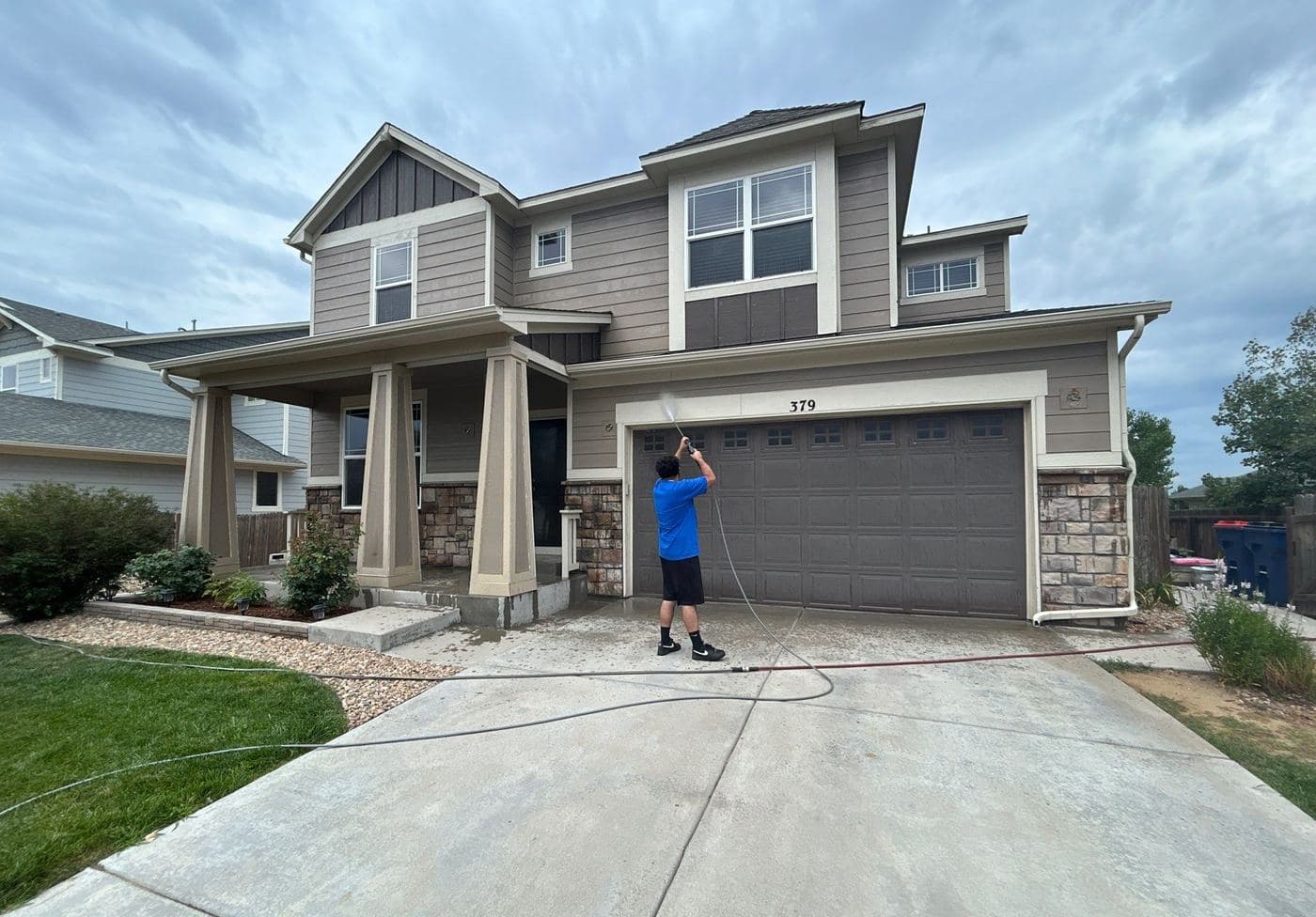 Painter pressure washing before an exterior repaint